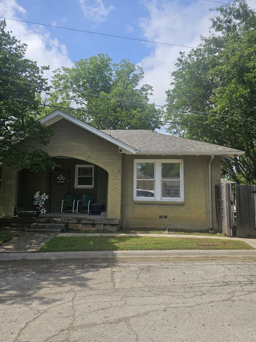 Yellow brick cottage with new roof in Johnson County, TX